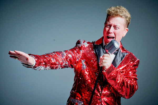 One of our male Las Vegas singers for events adorned in red sequined suit while passionately belting into microphone | Altus Entertainment